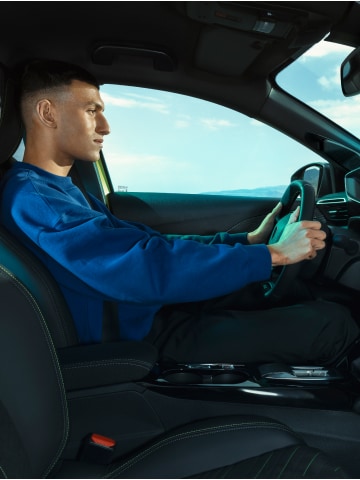 Un hombre conduciendo el PEUGEOT E-208