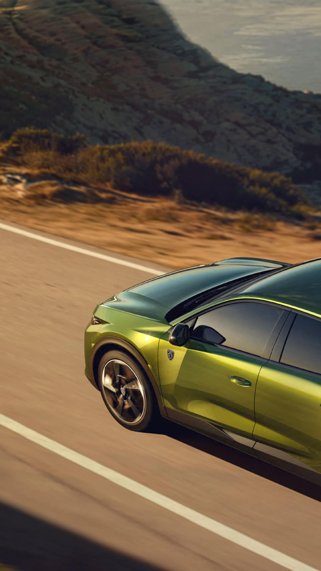 Nuevo PEUGEOT E-408 en una carretera junto al mar