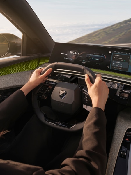 Hombre al volante de un PEUGEOT E-5008, detalle del i-Cockpit®.