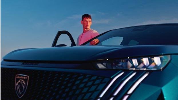 Hombre cerca del nuevo PEUGEOT E-3008 Azul Obsesión vista frontal